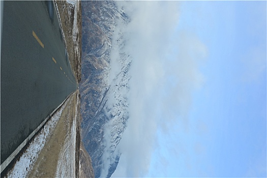 新疆阿勒泰地区山区路上野外风光冬季冬天公路雪山云雾