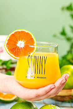 手上端着一杯橘子汁