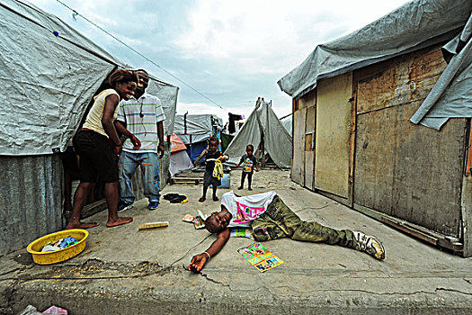 haiti,port,au,prince,man,lying,like,dead,in,camp,champ,de,mars