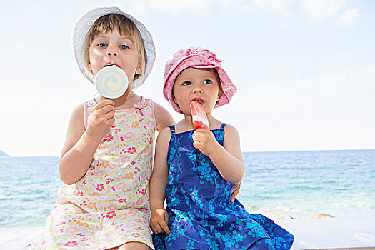女性,幼儿,姐妹,戴着,太阳帽,吃,冰棍,海滩