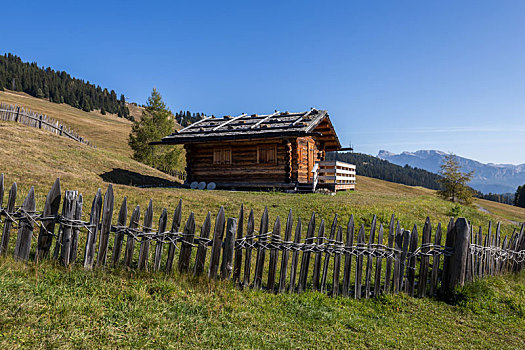 意大利多洛米蒂山脉苏西高原秋季草原上的木屋和山地风景