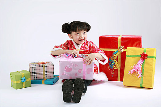 坐在一堆礼品盒中间的小女孩