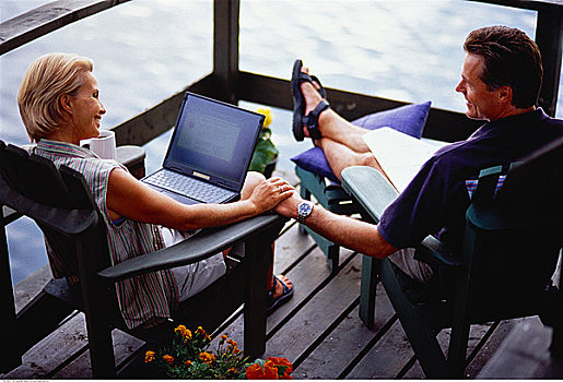夫妻,坐,宽木躺椅,甲板,笔记本电脑