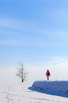 一个女人在雪地田埂上