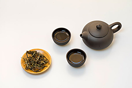 午后阳光下的黑色茶壶与茶叶