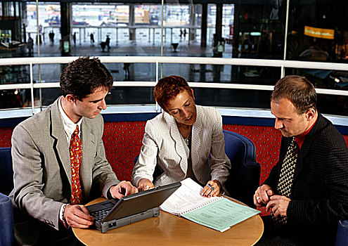 三个人,坐,桌子,一个,拿着,笔记本电脑