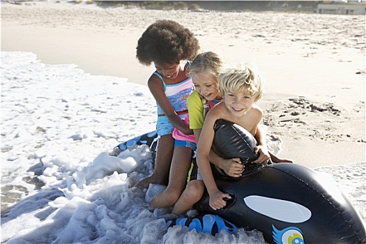 三个孩子,5-10岁,坐,充气玩具,鲸,海滩,玩,海浪,微笑