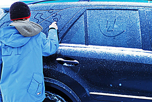 iceland,reykjavik,portrait,of,boy,drawing,with,snow,on,car
