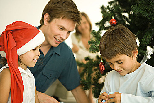 父亲,两个孩子,打开,圣诞礼物,正面,圣诞树,女孩,穿,圣诞帽