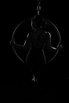 东方女子练习空中瑜伽黑色光影效果空中瑜伽