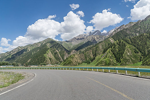 中国新疆夏季蓝天白云下高山森林g217独库公路弯道