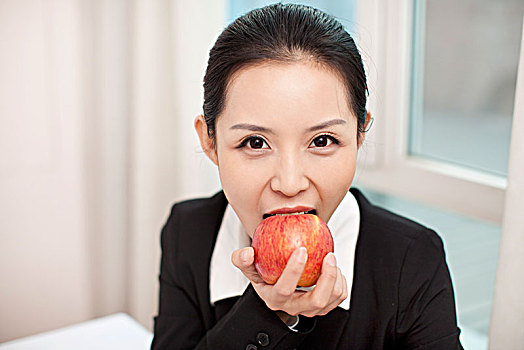 青年商务女士吃苹果