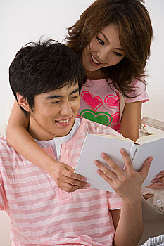 一对年轻的夫妇共看一本书