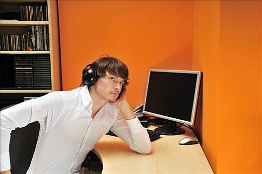 男青年,穿,耳机,坐,书桌,正面,电脑,听歌,思考