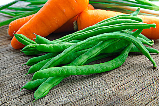 有机绿色蔬菜菜豆,是素食主义者健康重要维生素,豆子和紅蘿蔔在原木桌面上