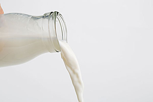 从瓶子里倒出的牛奶,牛奶的液体展现