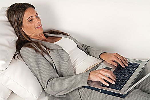 成熟,职业女性,躺着,沙发,打字,笔记本电脑