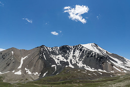 中国新疆夏季蓝天白云下g217独库公路沿途雪山草地