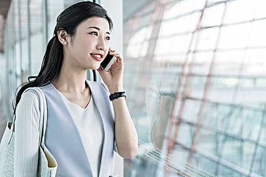 年輕商務(wù)女士在機(jī)場(chǎng)打電話