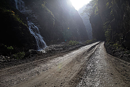 一段崎岖蜿蜒的岩石山路和山间瀑布