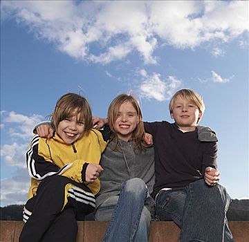 三个孩子,坐,矮墙,微笑