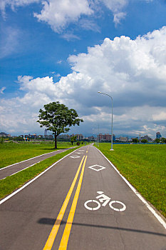 蓝天白云下的河边公园干净的自行车道