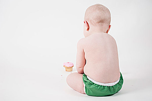 后视图,婴儿,看,杯形蛋糕,白色背景