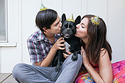 年轻,情侣,吻,狗,脸颊,戴着,派对帽