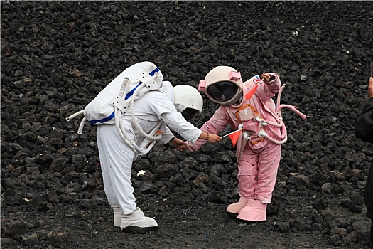 内蒙古火山口游客穿宇航服拿国旗拍照,宛若登陆外星球