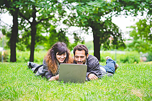正面,年轻,情侣,趴着,草地,使用笔记本,电脑,微笑