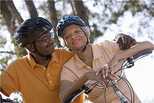活力老人,情侣,戴着,自行车头盔,马球衫,坐,自行车,公园,男人,搂抱,女人,微笑,头像,仰视,倾斜