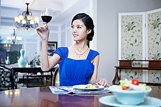 东方年轻女性在奢华别墅内用餐