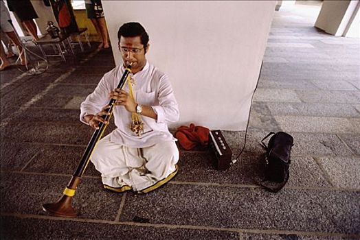 新加坡,小印度,男人,坐,地板,演奏,单簧管