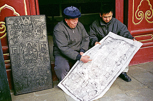 河南开封朱仙镇年画艺人在看刚引出的年画