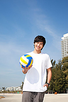 年轻人在海边玩沙滩排球
