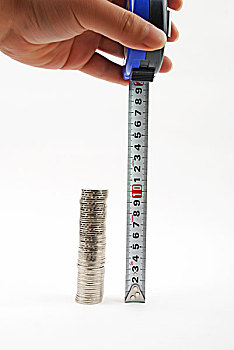 手拿尺子测量一摞硬币的高度