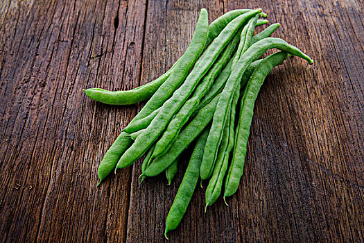 有机绿色蔬菜菜豆,是素食主义者健康重要维生素,豆子在原木桌面上