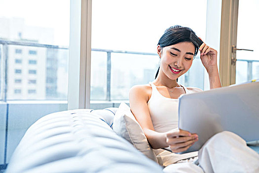 年輕女子在沙發(fā)上使用電腦