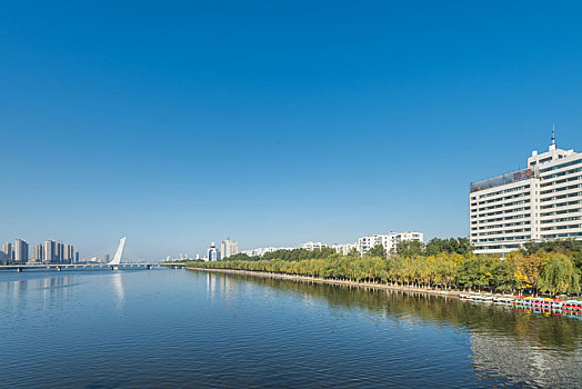 秋季中国抚顺蓝天下的城市河岸建筑和大桥