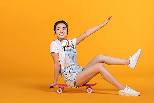 棚拍玩滑板的年轻女子