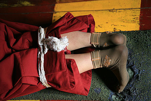 西藏米穷日寺的一个尼姑在磕长头将双脚束缚起来不能移动
