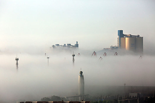 日照港出现平流雾奇观,几十米高的门机桥吊只露顶端