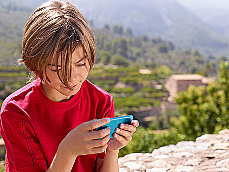 男孩,坐,石墙,看,智能手机,马略卡岛,西班牙