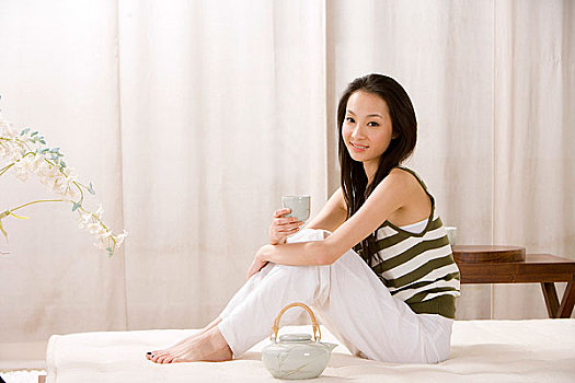 一个女人坐在床上品茶