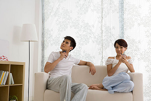 一對年輕的夫婦在家中沙發(fā)上化妝