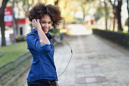 年轻,黑人女性,非洲发型,听,音乐,耳机,城市,背景,混合,有趣,女人,穿,蓝衬衫,短裤
