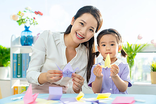 老师和小女孩一起折纸