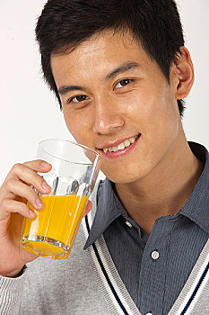 年轻男人喝果汁