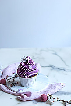 放在白色木桌子上的粉紫色香芋杯子蛋糕