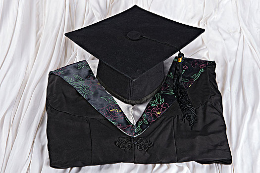 白色背景下的学士帽,毕业证书,学士服
